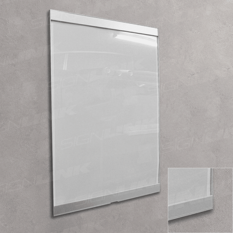 A large white rectangular wall sign or display board with a slim silver frame, mounted on a textured gray wall.