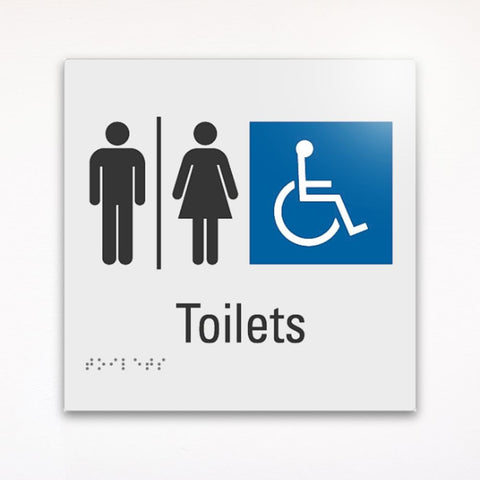 a gray and braille toilet sign saying Toilets with image of boy, girl and a wheel chair